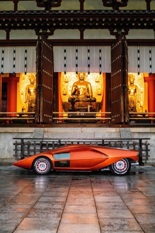 仏教寺院の前に停められたオレンジ色の車